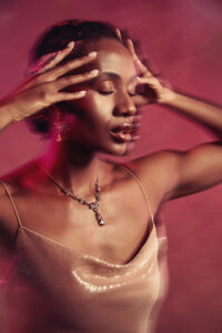 Creative lighting and blurred motion fashion studio photography of woman in champagne colored dress