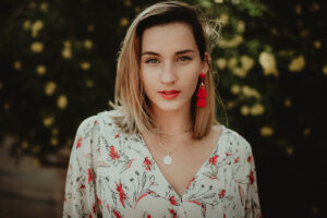 Beautiful photography portrait in Las Vegas of youn woman with colorful floral top and bold red earrings